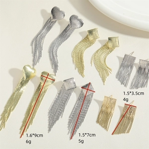 Minimalist gold and silver heart tassel drop earrings set in brushed metal texture
