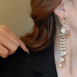 Detail of elegant silver tassel pearl earrings with zircon on model for formal styling