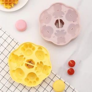 Pink and yellow cat paw silicone steamer mold for baby food making on white marble