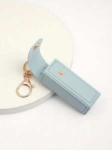 Detail of light blue pebble leather lipstick keychain case with golden metal clip