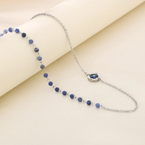 Detailed close-up of a silver chain necklace with blue beads and a star pendant