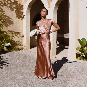 Detailed texture of rose gold satin evening dress with elegant metallic silk gloss
