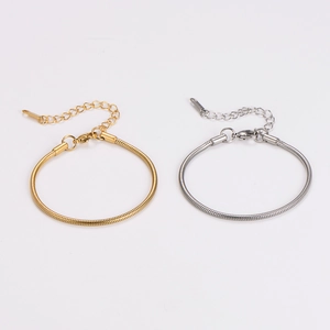Detail of gold and silver snake chain bracelets with lobster clasp and extension chain