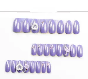 Detail of lavender almond press-on nails with white pearls, purple flowers and glitter
