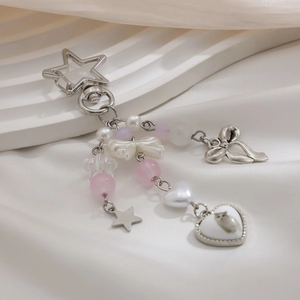 Close-up of heart cat pendant with beads and bowknot on a silver star keychain