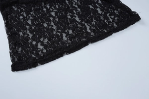 Close-up of black lace fabric showing intricate floral patterns and mesh texture