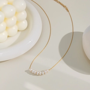 Elegant gold necklace featuring horizontal natural pearls and an adjustable chain