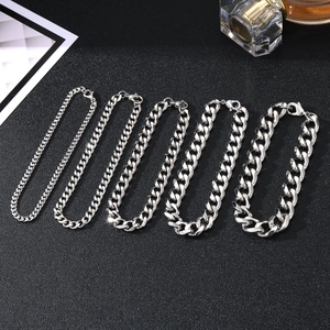 Five assorted thicknesses of men's silver stainless steel Cuban link bracelets on black