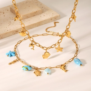 Détail de colliers en acier inoxydable doré avec pendentifs thème océan comme des étoiles de mer