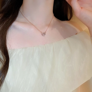 Detailed view of rose gold double ring necklace with zircon inlay on female neck
