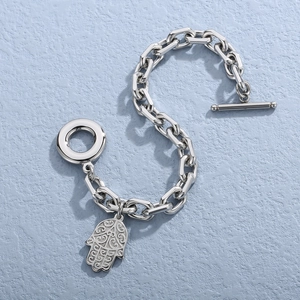 Polished stainless steel Hamsa hand bracelet with OT toggle clasp on blue background