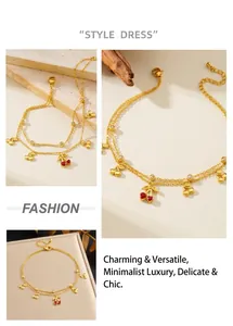 Detail of double-layer gold anklet featuring red heart cherry pendant and sparkling zircons