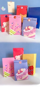 Close-up van kleurrijke papieren cadeauzakjes met beertjes en verjaardagstaarten