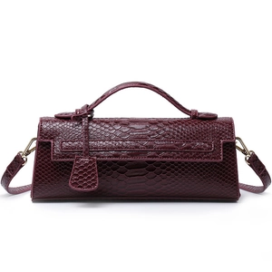 Deep red snakeskin embossed baguette bag with gold hardware and top handle strap