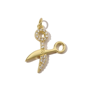 Macro shot of gold-plated scissor pendant with sparkling cubic zirconia stones