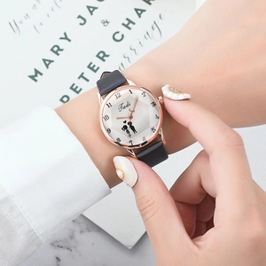 Détail d'une montre femme en or rose avec silhouette de couple et bracelet en cuir