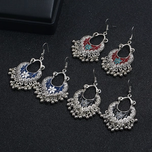 Detail of silver Indian style bell earrings with blue red and black enamel floral patterns