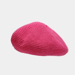 Detailed view of magenta knitted wool beret featuring thick spiral weave texture