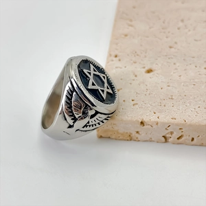 Detail van een vintage roestvrijstalen ring met hexagram en adelaarsvleugel details
