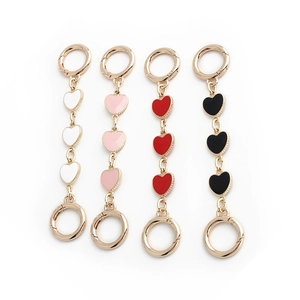 Golden heart-shaped chain extender charms in white, pink, red, and black finishes