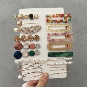 Detail view of colorful acetate hair clips set with pearls and marble textures