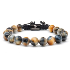 Detailed macro view of 10mm tiger eye beads and engraved metal plaque on a woven bracelet