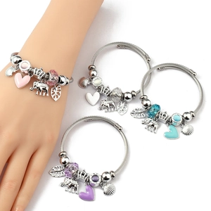 Detail of beaded charm bracelets with elephant and heart pendants on steel cable