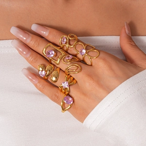 Detail of trendy gold stainless steel rings with pink zircons worn by a model