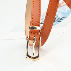 Brown slim leather belt for women with golden buckle and stitching detail on white background