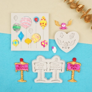 Detailed view of silicone molds with finished Merry Christmas and North Pole sign pendants