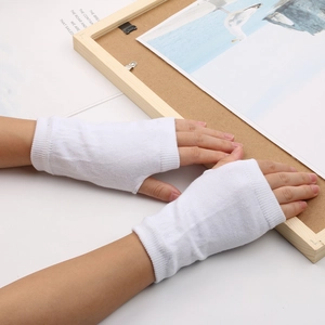 Gants blancs tricotés sans doigts portés au poignet avec un décor intérieur minimaliste