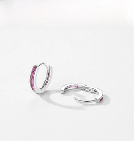 Detail of S925 silver huggie earrings with channel-set red baguette-cut cubic zirconia