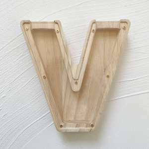 Macro detail of the V-shaped oak wood money jar with clear acrylic front panel