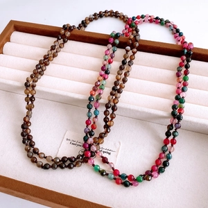 Macro detail of multilayered agate beaded long necklace on velvet jewelry tray display