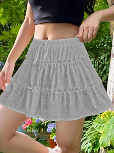 Detail of grey tiered ruffle skirt featuring high-waist drawstring and knit texture