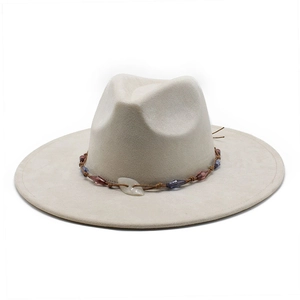 Detail of beige wide brim fedora featuring woven band with blue beads and leaf ornament
