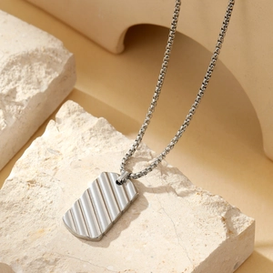 Detailed shot of silver titanium pendant necklace with vertical ripple texture on stones