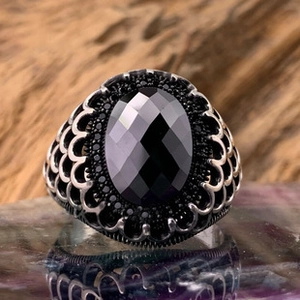 Macro shot of vintage silver ring featuring oval black agate and ornate carved textures