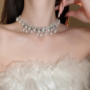 Detail of silver rhinestone necklace with cascading white and grey pearl pendants on model