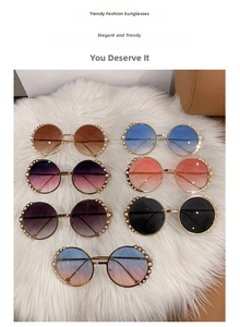 Flat lay of round pearl-embellished oversized sunglasses in seven diverse colors