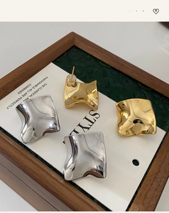 Detailed view of wavy irregular liquid metal earrings in gold and silver finish