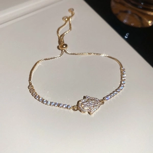 Detailed close-up of a golden Hamsa hand bracelet with zircon pavé and adjustable chain