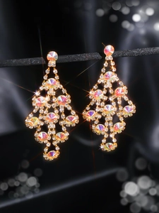 Detail of long gold earrings with sparkling crystals and iridescent AB stones on black silk