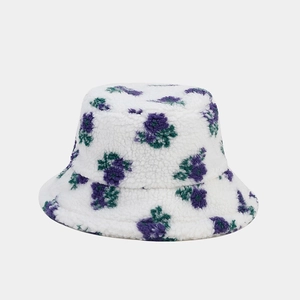 Gros plan du bob en polaire blanche avec détails de broderies florales violettes et vertes