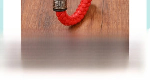 Vue détaillée du bracelet en cuir tressé rouge avec fermoir gravé en acier titane