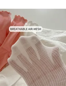 Close-up of breathable mesh texture and ruffled lace edges on white cotton socks
