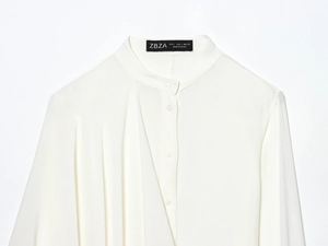 Detail of white long sleeve shirt showing round neck collar and button closure
