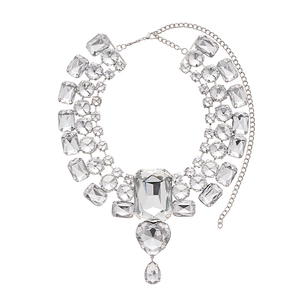 Exaggerated silver necklace with heart diamond and geometric rhinestones on white background