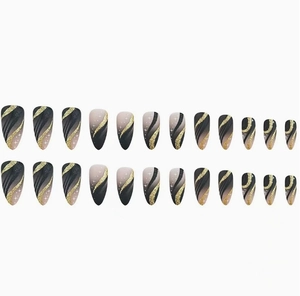 Detail of almond-shaped press-on nails with black gold gradient and glitter stars