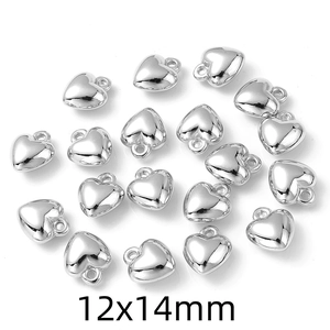 Flat lay of silver CCB heart charms with 12x14mm size labels on a white background